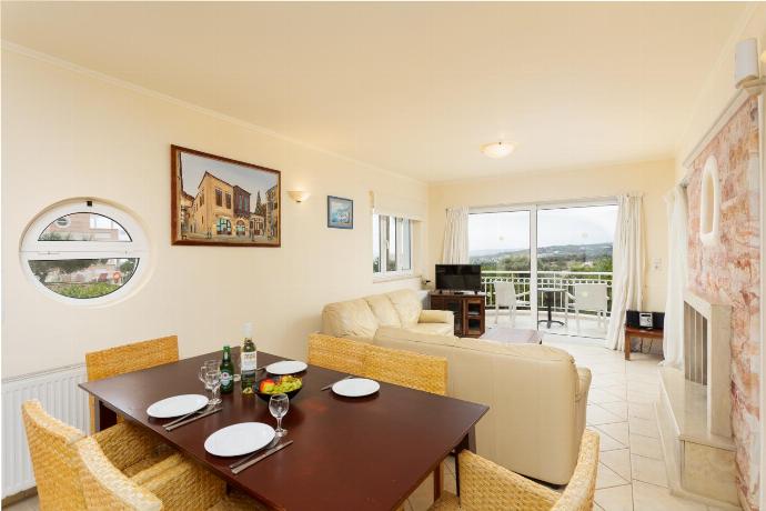 Open-plan living room with sofas, dining area, kitchen, ornamental fireplace, A/C, WiFi internet, and satellite TV . - Villa Callistemon . (Galerie de photos) }}