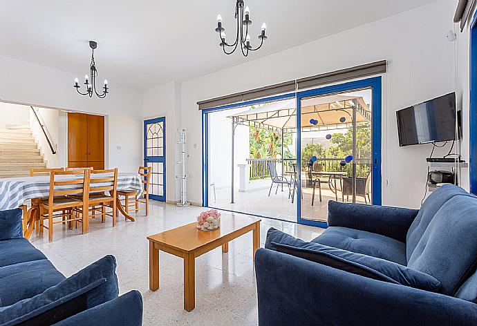 Open-plan living room with sofas, dining area, kitchen, A/C, WiFi internet, satellite TV, DVD player, and terrace access . - Villa Charoula Tria . (Galería de imágenes) }}