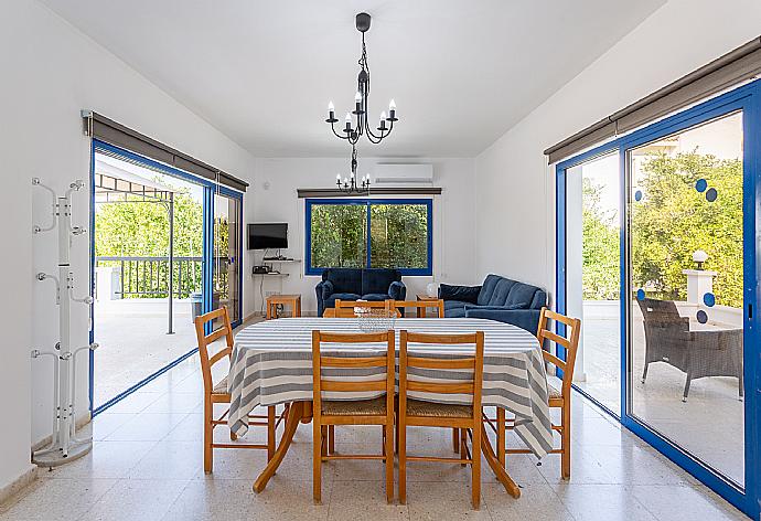 Open-plan living room with sofas, dining area, kitchen, A/C, WiFi internet, satellite TV, DVD player, and terrace access . - Villa Charoula Tria . (Galería de imágenes) }}