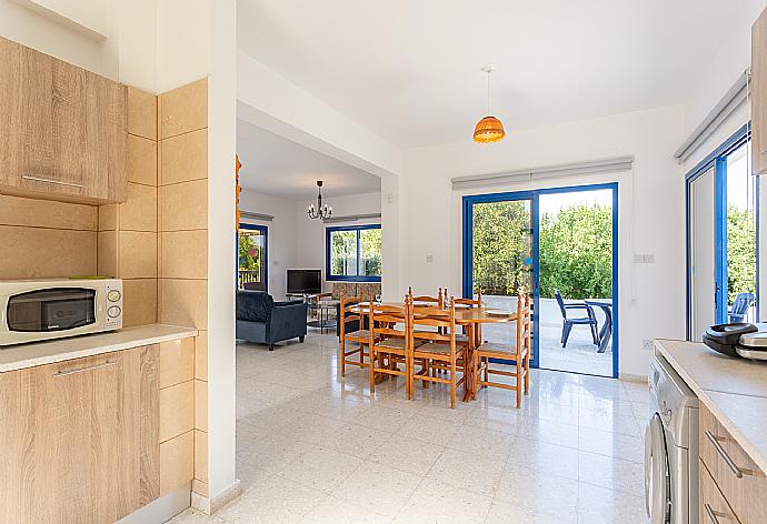 Open-plan living room with sofas, dining area, kitchen, WiFi internet, satellite TV, DVD player, and terrace access . - Villa Charoula Pente . (Fotogalerie) }}