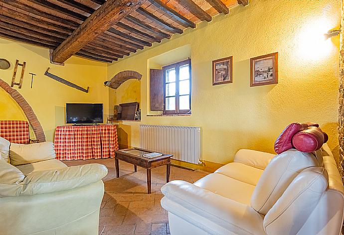 Open-plan living room on ground floor with sofas, dining area, kitchen, ornamental fireplace, WiFi internet, satellite TV, DVD player, and terrace access . - Villa Podere Belvedere . (Fotogalerie) }}