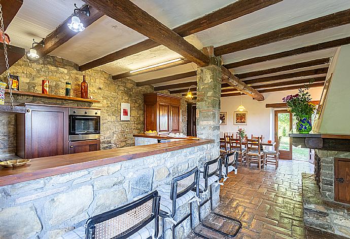 Open-plan dining area with equipped kitchen and ornamental fireplace  . - Villa Caporlese . (Galleria fotografica) }}