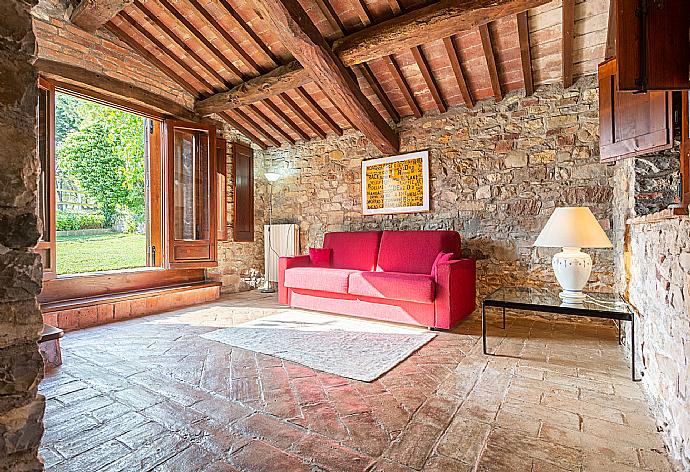 Living area with sofa and garden access . - Villa Caporlese . (Galerie de photos) }}