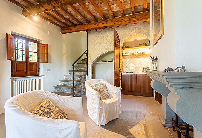 Open-plan living room in annex with sofa-bed, dining area, kitchenette, and ornamental fireplace . - Villa Caporlese . (Galerie de photos) }}