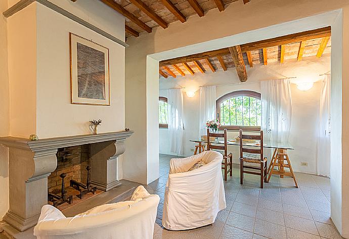 Open-plan living room in annex with sofa-bed, dining area, kitchenette, and ornamental fireplace . - Villa Caporlese . (Galerie de photos) }}