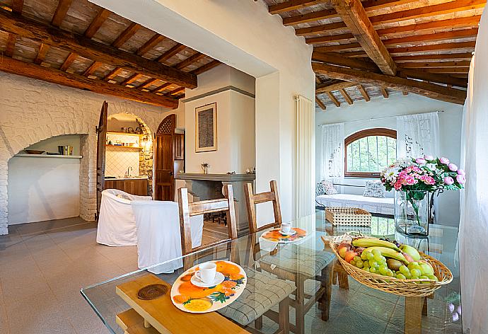 Open-plan living room in annex with sofa-bed, dining area, kitchenette, and ornamental fireplace . - Villa Caporlese . (Galerie de photos) }}