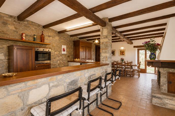Open-plan dining area with equipped kitchen and ornamental fireplace . - Villa Caporlese . (Galerie de photos) }}