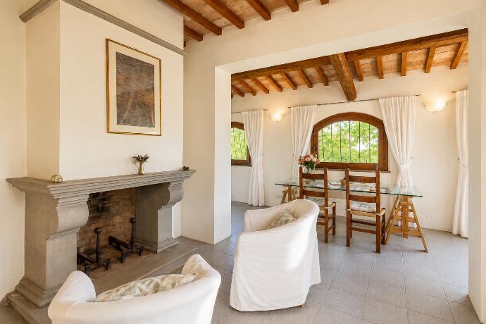 Open-plan living room in annex with sofa-bed, dining area, kitchenette, and ornamental fireplace . - Villa Caporlese . (Galerie de photos) }}