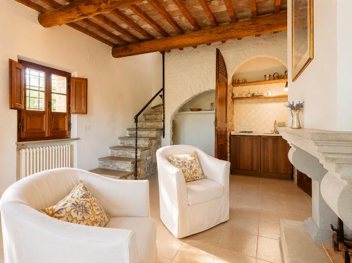 Open-plan living room in annex with sofa-bed, dining area, kitchenette, and ornamental fireplace . - Villa Caporlese . (Galerie de photos) }}