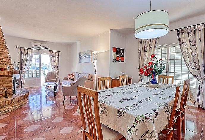 Open-plan living room with ornamental fireplace,TV and dining area  . - Villa Palmeira . (Fotogalerie) }}