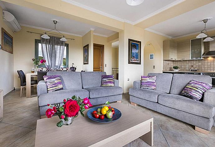 Open-plan living room with sofas, dining area, kitchen, ornamental fireplace, A/C, WiFi internet, satellite TV, DVD player, and sea views . - Rose Villa . (Fotogalerie) }}