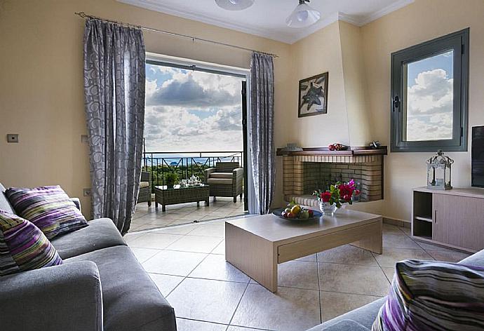 Open-plan living room with sofas, dining area, kitchen, ornamental fireplace, A/C, WiFi internet, satellite TV, DVD player, and sea views . - Rose Villa . (Fotogalerie) }}