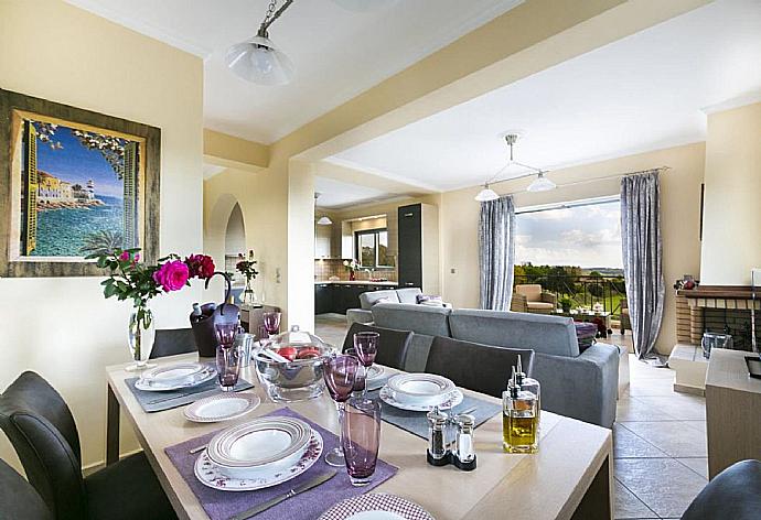 Open-plan living room with sofas, dining area, kitchen, ornamental fireplace, A/C, WiFi internet, satellite TV, DVD player, and sea views . - Rose Villa . (Galleria fotografica) }}