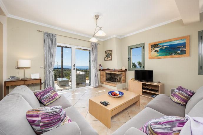 Open-plan living room with sofas, dining areas, kitchen, ornamental fireplace, A/C, WiFi internet, satellite TV, and sea views . - Rose Villa . (Photo Gallery) }}