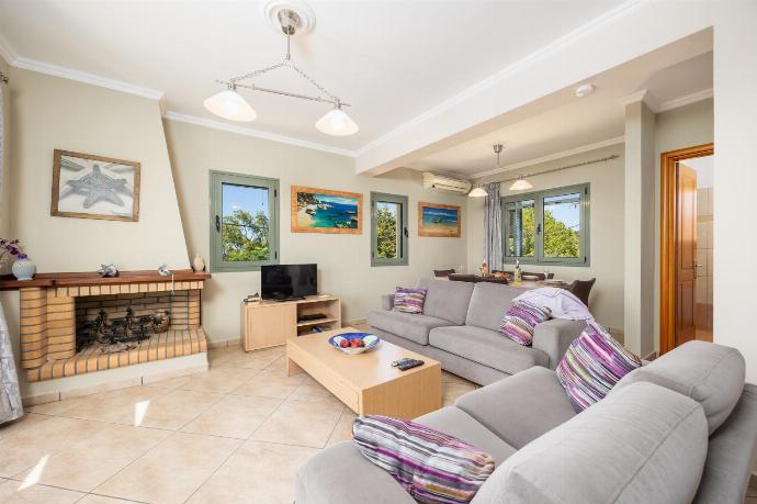 Open-plan living room with sofas, dining areas, kitchen, ornamental fireplace, A/C, WiFi internet, satellite TV, and sea views . - Rose Villa . (Photo Gallery) }}
