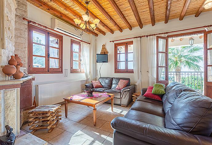 Open-plan living room with sofas, dining area, kitchen, ornamental fireplace, A/C, WiFi internet, satellite TV, and balcony/terrace access . - Villa Alexandros Palace . (Fotogalerie) }}