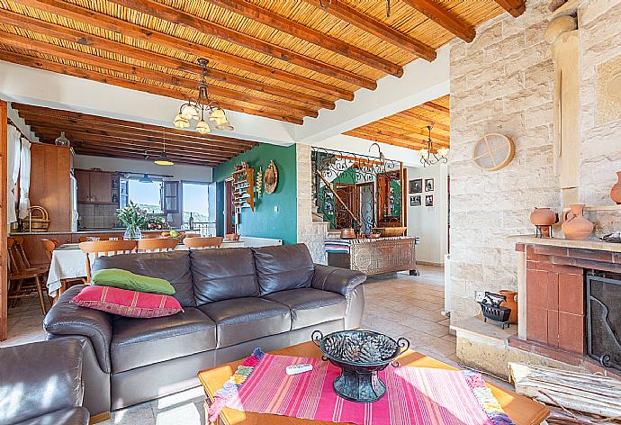 Open-plan living room with sofas, dining area, kitchen, ornamental fireplace, A/C, WiFi internet, satellite TV, and balcony/terrace access . - Villa Alexandros Palace . (Fotogalerie) }}