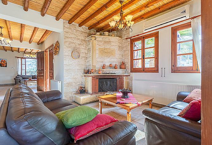 Open-plan living room with sofas, dining area, kitchen, ornamental fireplace, A/C, WiFi internet, satellite TV, and balcony/terrace access . - Villa Alexandros Palace . (Galería de imágenes) }}