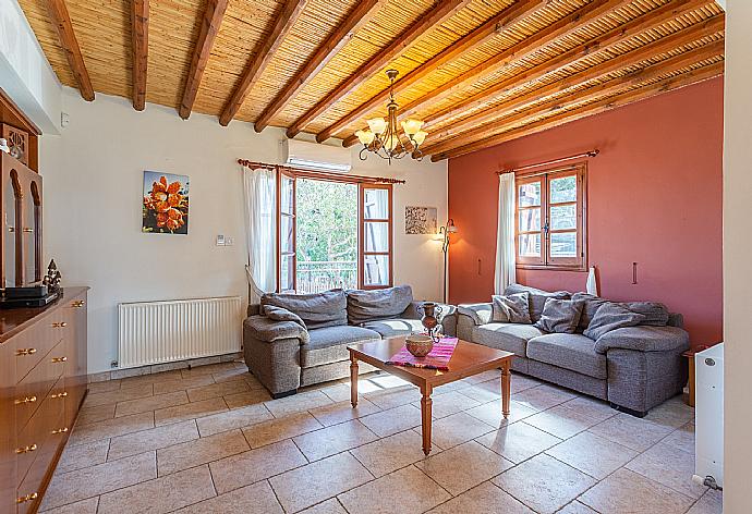 Open-plan living room with sofas, dining area, kitchen, ornamental fireplace, A/C, WiFi internet, satellite TV, and balcony/terrace access . - Villa Alexandros Palace . (Fotogalerie) }}