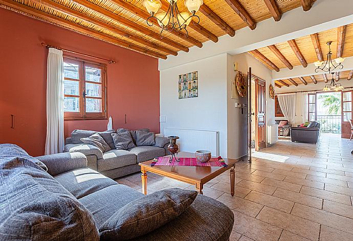 Open-plan living room with sofas, dining area, kitchen, ornamental fireplace, A/C, WiFi internet, satellite TV, and balcony/terrace access . - Villa Alexandros Palace . (Fotogalerie) }}