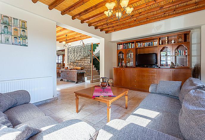 Open-plan living room with sofas, dining area, kitchen, ornamental fireplace, A/C, WiFi internet, satellite TV, and balcony/terrace access . - Villa Alexandros Palace . (Fotogalerie) }}