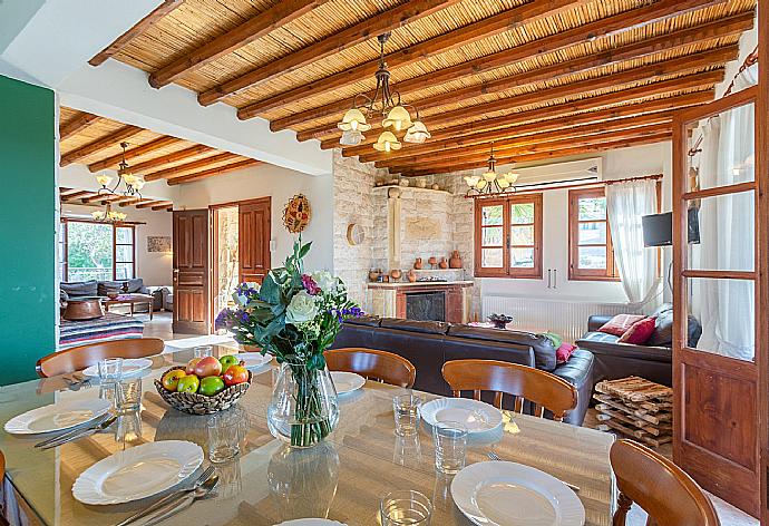 Open-plan living room with sofas, dining area, kitchen, ornamental fireplace, A/C, WiFi internet, satellite TV, and balcony/terrace access . - Villa Alexandros Palace . (Fotogalerie) }}