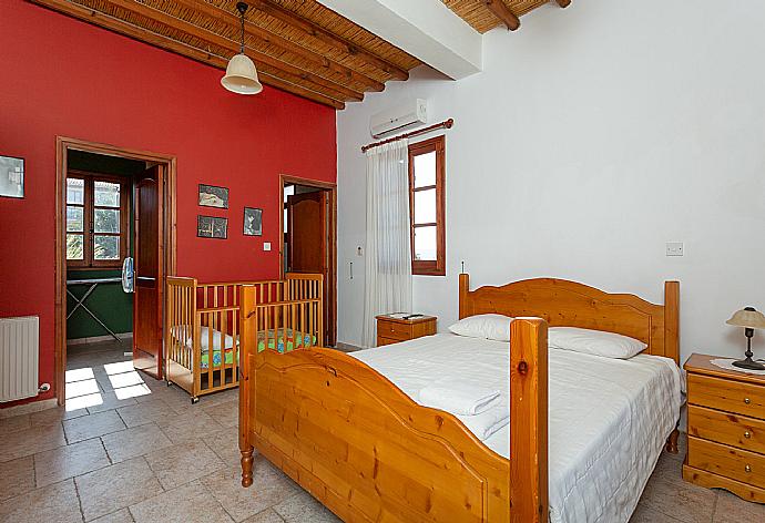 Double bedroom with en suite bathroom, A/C, TV, and balcony access . - Villa Alexandros Palace . (Galerie de photos) }}