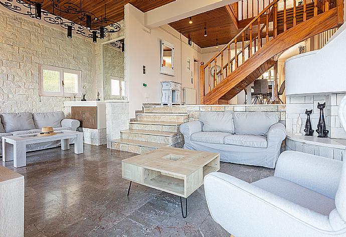 Open-plan living room with sofas, dining area, kitchen, ornamental fireplace, A/C, WiFi internet, satellite TV, and sea views . - Villa Litsa . (Galería de imágenes) }}