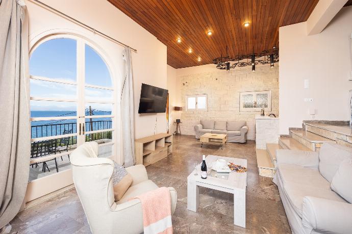 Living room with sofas, ornamental fireplace, A/C, WiFi internet, satellite TV, and sea views . - Villa Litsa . (Photo Gallery) }}