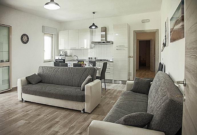Open-plan living room with sofas, dining area, kitchen, WiFi internet, satellite TV, DVD player, and terrace access . - Villa Villino Blu . (Fotogalerie) }}