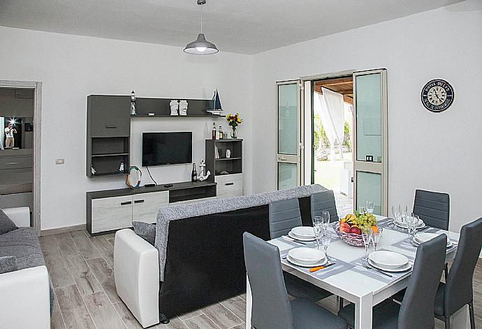 Open-plan living room with sofas, dining area, kitchen, WiFi internet, satellite TV, DVD player, and terrace access . - Villa Villino Blu . (Fotogalerie) }}