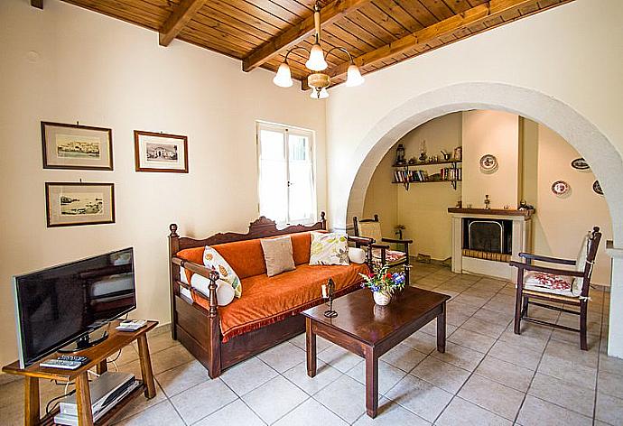 Open-plan living room with sofas, dining area, kitchen, ornamental fireplace, A/C, WiFi internet, and satellite TV . - Villa Helianthos 1 . (Fotogalerie) }}