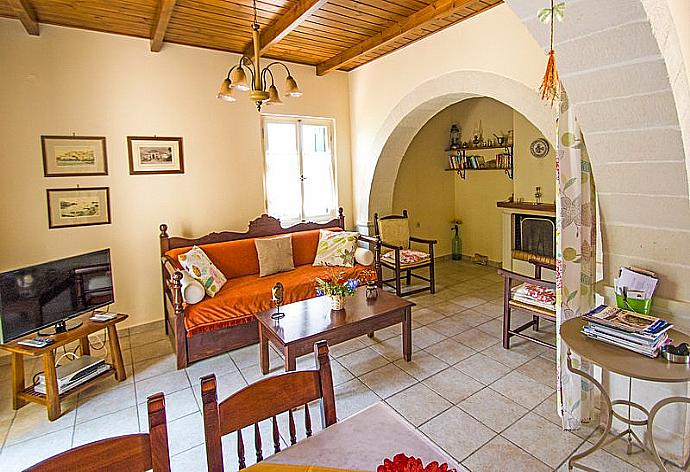 Open-plan living room with sofas, dining area, kitchen, ornamental fireplace, A/C, WiFi internet, and satellite TV . - Villa Helianthos 1 . (Fotogalerie) }}