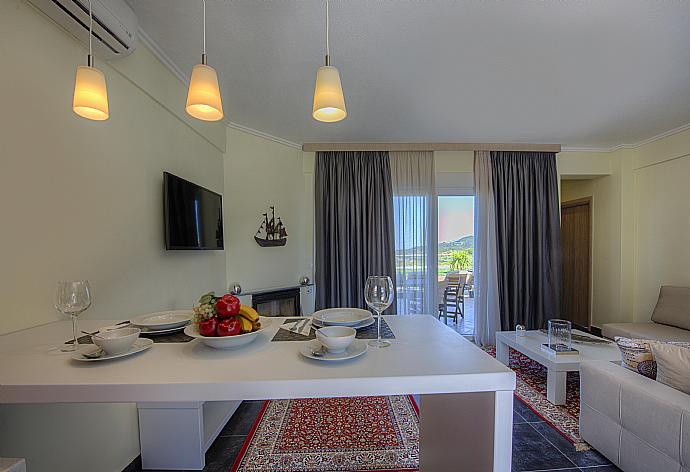 Living room with dining area and terrace access . - Grand Villa Athos . (Photo Gallery) }}