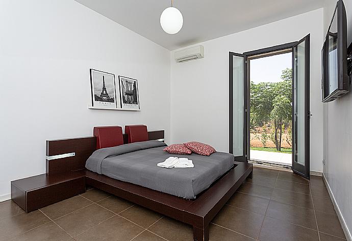 Double bedroom with en suite bathroom, A/C, TV, walk-in wardrobe, and terrace access . - Villa Akos . (Photo Gallery) }}