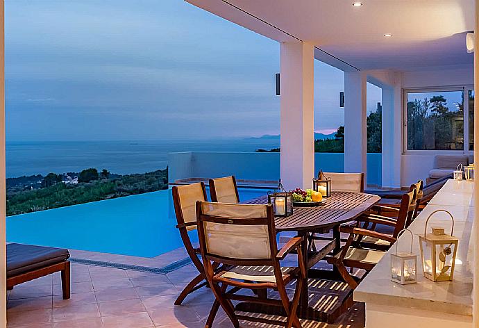 Outdoor dining at night  . - Villa Porfyra . (Fotogalerie) }}