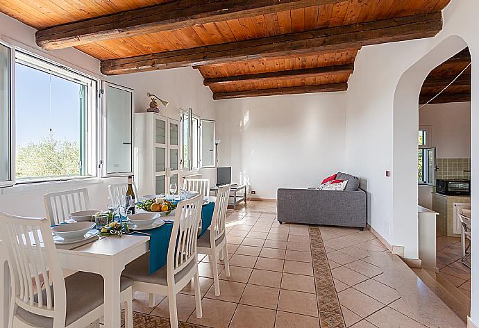 Open-plan living room with sofa, dining area, kitchen, A/C, WiFi internet, satellite TV, and terrace access . - Villa Benjamin . (Fotogalerie) }}