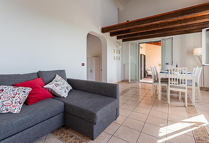 Open-plan living room with sofa, dining area, kitchen, A/C, WiFi internet, satellite TV, and terrace access . - Villa Benjamin . (Fotogalerie) }}