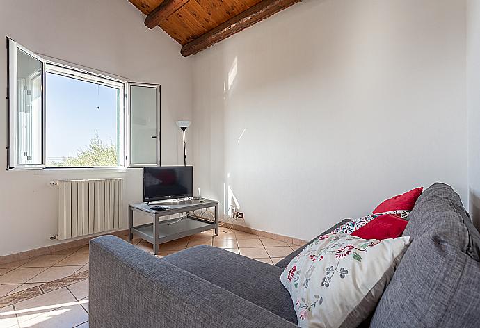 Open-plan living room with sofa, dining area, kitchen, A/C, WiFi internet, satellite TV, and terrace access . - Villa Benjamin . (Fotogalerie) }}