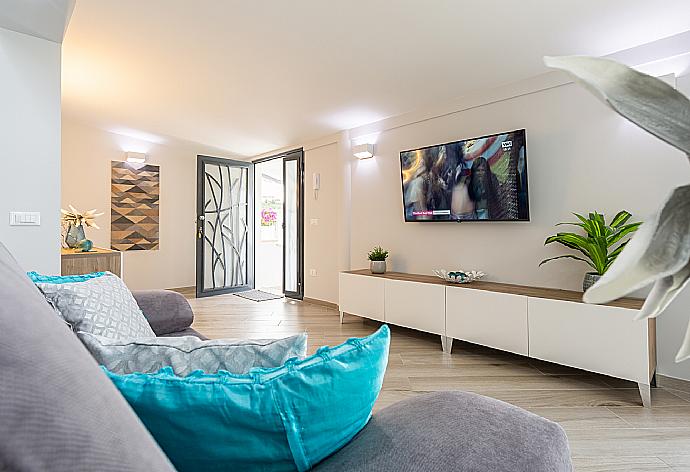Open-plan living room with sofa, dining area, kitchen, A/C, WiFi internet, satellite TV, and terrace access . - Villa Marianna . (Photo Gallery) }}