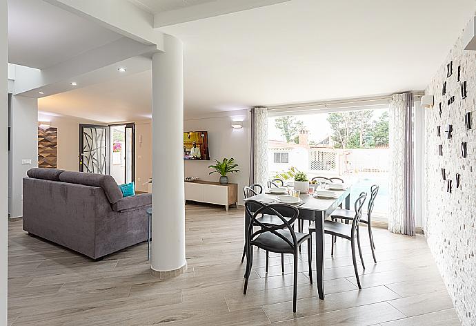 Open-plan living room with sofa, dining area, kitchen, A/C, WiFi internet, satellite TV, and terrace access . - Villa Marianna . (Fotogalerie) }}