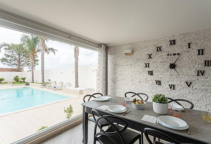 Open-plan living room with sofa, dining area, kitchen, A/C, WiFi internet, satellite TV, and terrace access . - Villa Marianna . (Fotogalerie) }}