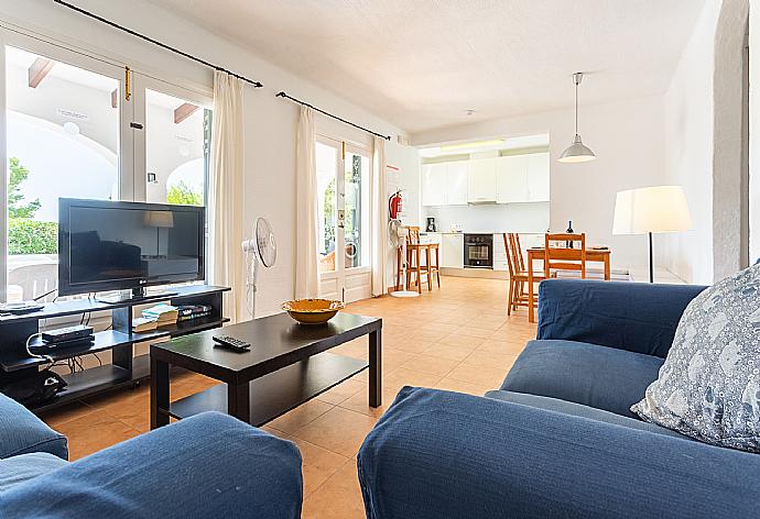 Open-plan living room with sofas, dining area, kitchen, A/C, WiFi internet, satellite TV, and terrace access . - Villa Binimary . (Fotogalerie) }}