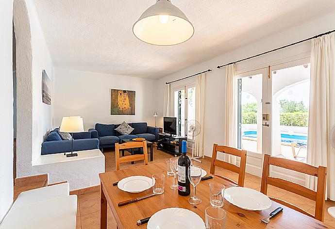 Open-plan living room with sofas, dining area, kitchen, A/C, WiFi internet, satellite TV, and terrace access . - Villa Binimary . (Fotogalerie) }}