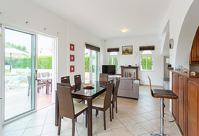 Open-plan living room with sofas, dining area, kitchen, ornamental fireplace, WiFi internet, satellite TV, and pool terrace access . - Villa Chrysanthemum . (Fotogalerie) }}