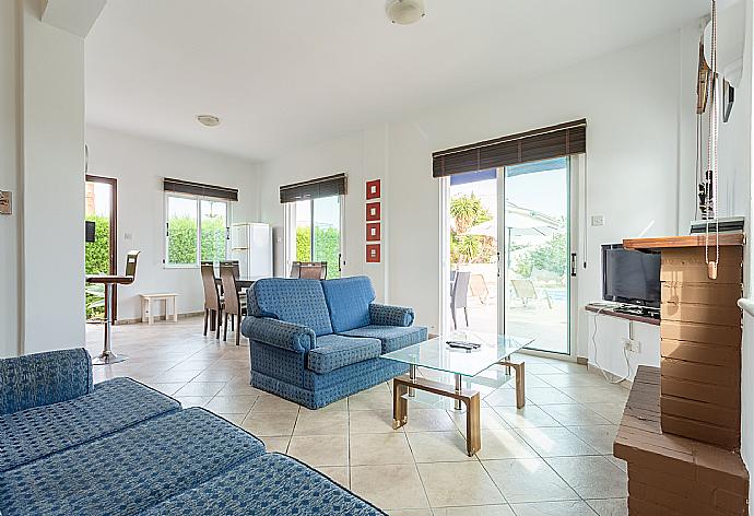 Open-plan living room with sofas, dining area, kitchen, ornamental fireplace, WiFi internet, satellite TV, and pool terrace access . - Villa Cleopatra . (Fotogalerie) }}