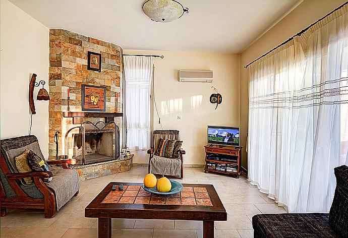 Living area with fire place  . - Villa Niki . (Photo Gallery) }}