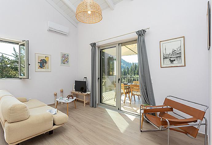 Open-plan living room with sofa, dining area, mezzanine, kitchen, A/C, WiFi internet, and satellite TV . - Villa Ifigeneia . (Fotogalerie) }}