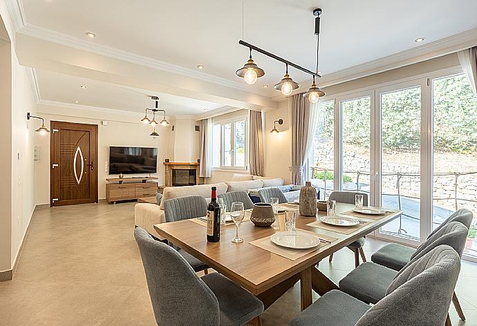 Open-plan living room with sofas, dining area, kitchen, ornamental fireplace, WiFi internet, and satellite TV . - Villa Nikolakis . (Galleria fotografica) }}