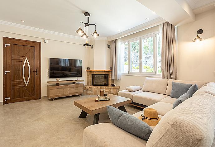 Open-plan living room with sofas, dining area, kitchen, ornamental fireplace, WiFi internet, and satellite TV . - Villa Nikolakis . (Galleria fotografica) }}